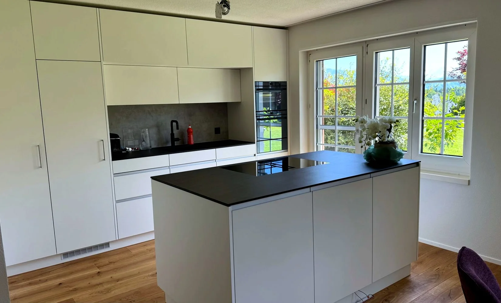 Elegante Küche mit warmem Holz und grosser Arbeitsfläche
